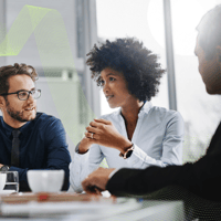 Group of people in discussion whilst sat at table