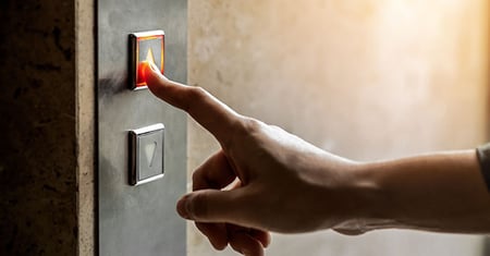 Hand pushing elevator button