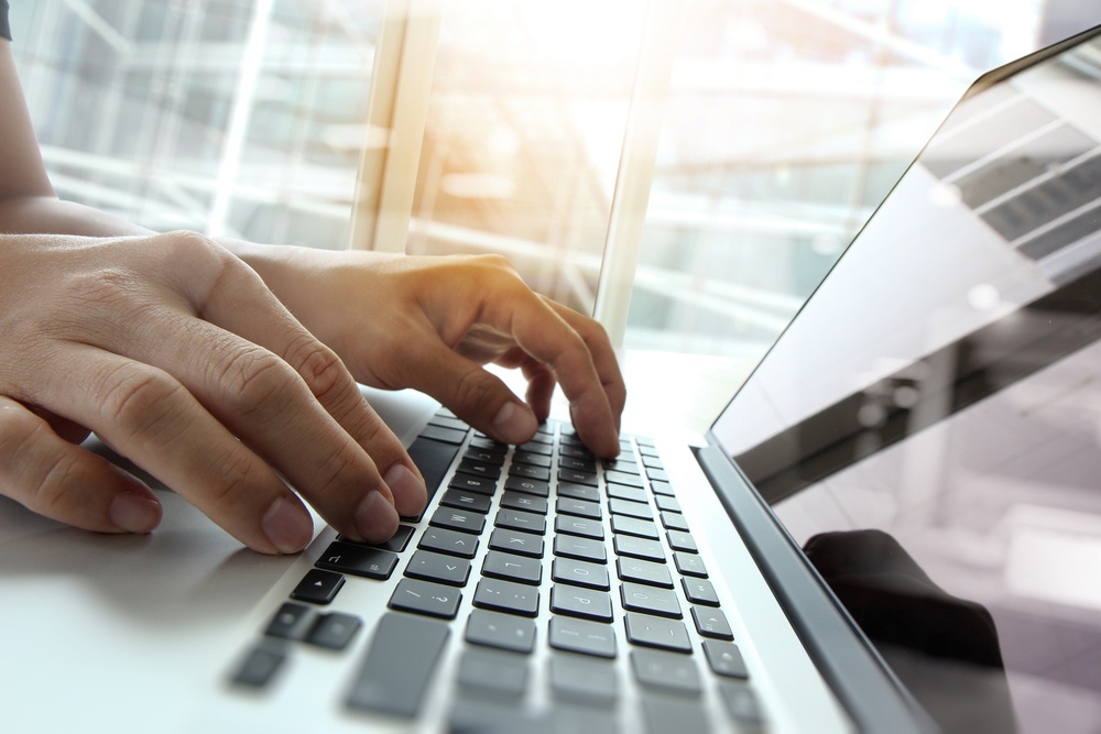 Double exposure of business man hand working on blank screen laptop computer on wooden desk as concept.jpeg